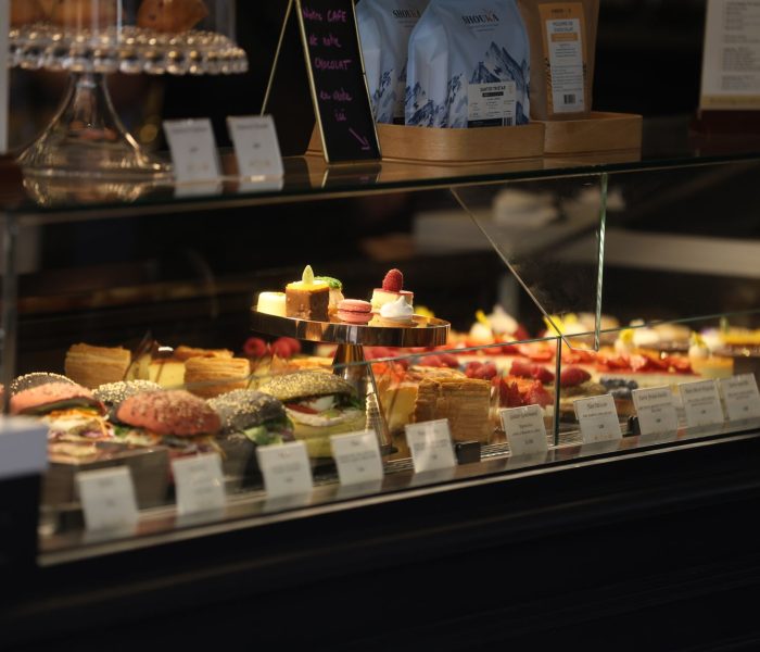 Gourmet pastries and sandwiches in a French bakery display case in Évian-les-Bains, France.